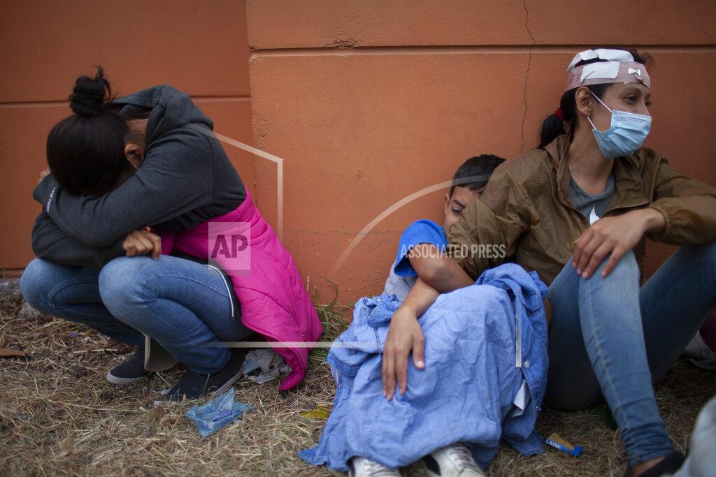 FILE - In this Jan. 17, 2021, file photo injured women, part of a Honduran migrant caravan in their bid to reach the U.S. border, weep as they sit on the side of a highway after clashing with Guatemalan police and soldiers in Vado Hondo, Guatemala, Guatemala. U.S. Federal law allows immigrants facing credible threats of persecution or violence in their home country to seek U.S. asylum. (AP Photo/Sandra Sebastian, File)