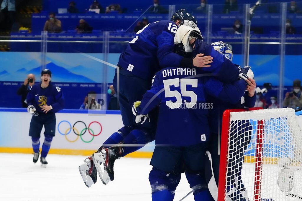 Matt Slocum Finland's Marko Anttila (12) jumps on Atte Ohtamaa (55) and goalkeeper Harri Sateri after Finland beat Russian Olympic Committee to win the men's gold medal hockey game at the 2022 Winter Olympics, Sunday, Feb. 20, 2022, in Beijing. (AP Photo/Matt Slocum)