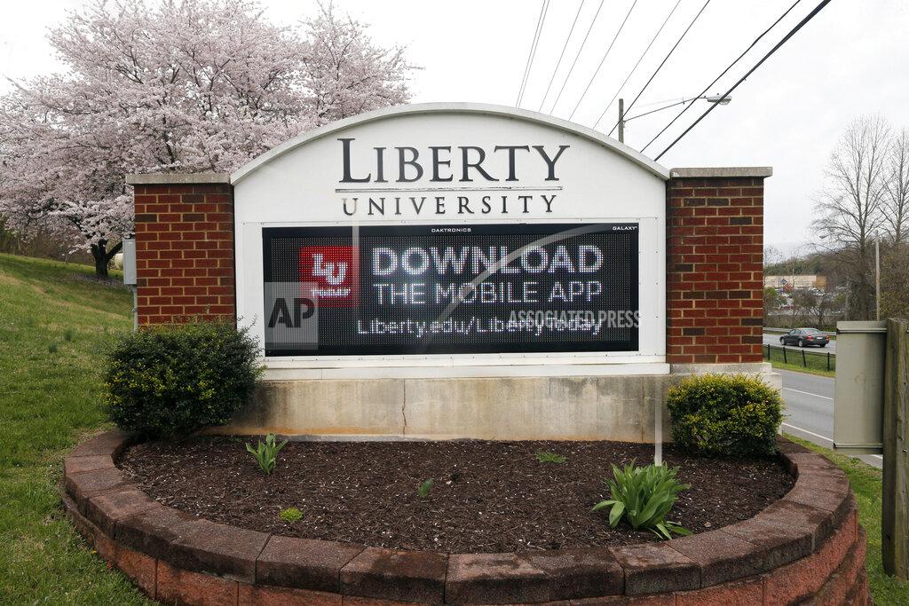 FILE - In this March 24, 2020 file photo, a sign marks the entrance to Liberty University, Tuesday March 24 , 2020, in Lynchburg, Va. Jerry Falwell Jr. said Tuesday, Aug. 25, that he has resigned as head of evangelical Liberty University because of ongoing controversies about his wife’s sexual involvement with a younger business partner and in the wake of a social media photo that caused an uproar. (AP Photo/Steve Helber)