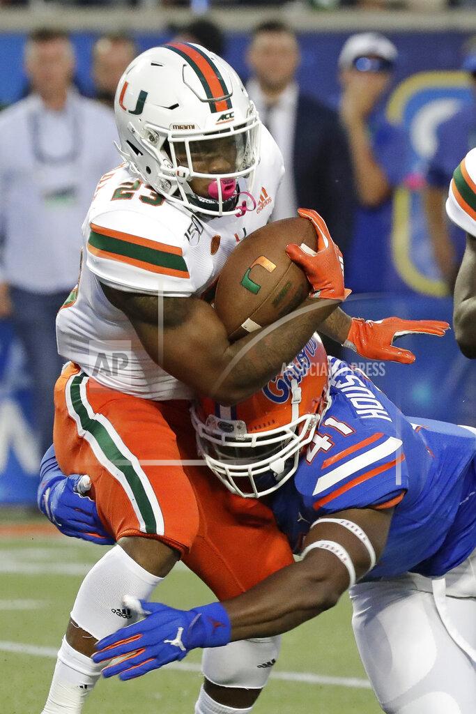 John Raoux Miami running back Cam'Ron Harris, left, is stopped by Florida linebacker James Houston IV on a run during the first half of an NCAA college football game Saturday, Aug. 24, 2019, in Orlando, Fla. (AP Photo/John Raoux)