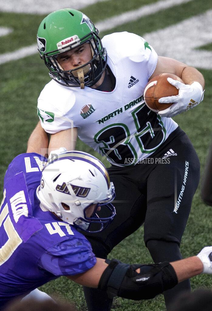 Daniel Lin North Dakota running back Dalton Gee (35) gets tackled by James Madison defensive lineman Mike Wilcox (47) during the first half of a quarterfinal game in the NCAA FCS football playoffs in Harrisonburg, Va., Sunday, May 2, 2021. (Daniel Lin/Daily News-Record via AP)