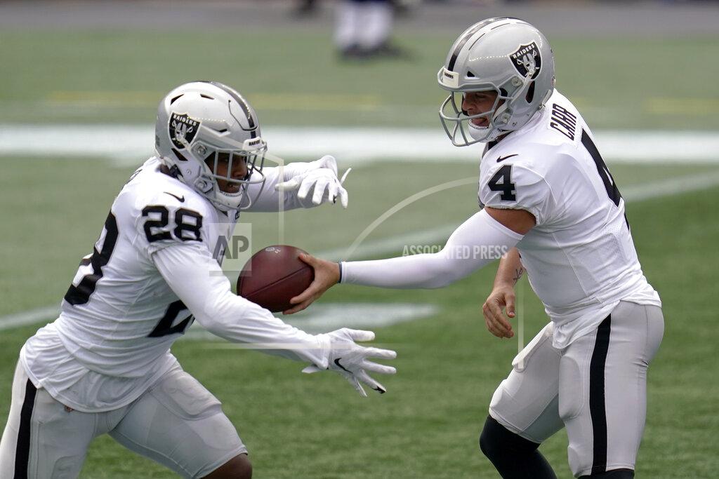 Charles Krupa Las Vegas Raiders quarterback Derek Carr (4) hands off to running back Josh Jacobs (28) in the first half of an NFL football game against the New England Patriots, Sunday, Sept. 27, 2020, in Foxborough, Mass. (AP Photo/Charles Krupa)