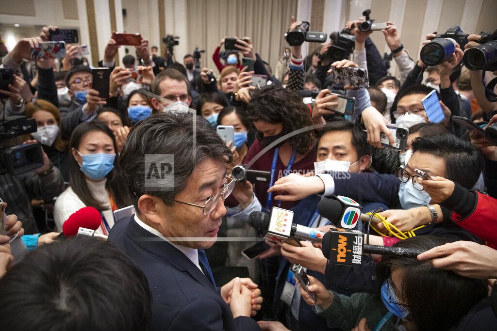FILE - In this Sunday, Jan. 26, 2020 file photo, Gao Fu, foreground left, the head of the Chinese Center for Disease Control and Prevention, speaks to journalists after a news conference about a virus outbreak at the State Council Information Office in Beijing. On Dec. 31, 2019, Gao dispatched a team of experts to Wuhan. Also on Dec. 31, the World Health Organization first learned about the cases from an open-source platform that scouts for intelligence on outbreaks, emergencies chief Michael Ryan has said. (AP Photo/Mark Schiefelbein)
