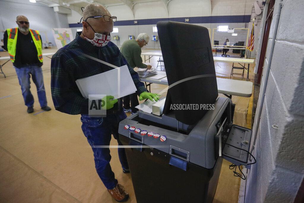 Tork Mason Poll worker Eric Boson submits absentee ballots during the Wisconsin 7th District special election on Tuesday, May 12, 2020, at the Oak Avenue Community Center in Marshfield, Wis. Republican Tom Tiffany and Democrat Tricia Zunker are vying to fill the vacancy left by Republican Sean Duffy, who resigned from the seat in September. (Tork Mason/The Post-Crescent via AP)