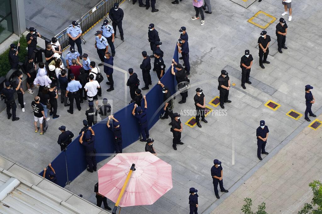 Ng Han Guan Investors are surrounded by police and security personnel as they try to enter the headquarters of the real estate developer Evergrande Group, Thursday, Sept. 23, 2021, in Shenzhen, southern China. Fears that the developer's possible default on multibillion-dollar debts might send shockwaves through global financial markets appeared to ease Thursday as creditors waited to see how much they might recover. (AP Photo/Ng Han Guan)