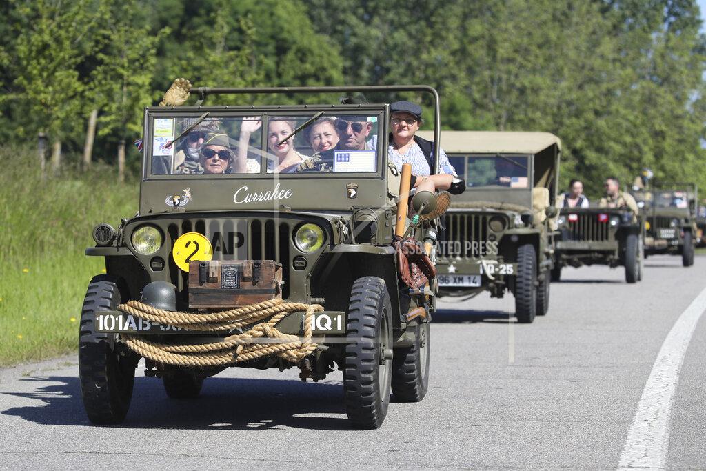 David Vincent World War II history enthusiasts parade in WWII vehicles in Ouistreham, Normandy, Saturday June, 5 2021 on the eve of 77th anniversary of the assault that helped bring an end to World War II. While France is planning to open up to vaccinated visitors starting next week, that comes too late for the D-Day anniversary. So for the second year in a row, most public commemoration events have been cancelled. A few solemn ceremonies have been maintained, in the presence of dignitaries and a few guests only. (AP Photo/David Vincent)