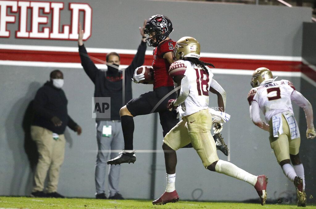 Ethan Hyman North Carolina State wide receiver Thayer Thomas (5) heads into the end zone in front of Florida State defensive back Travis Jay (18) on a 24-yard touchdown reception during the second half of an NCAA college football game Saturday, Nov. 14, 2020, in Raleigh, N.C. (Ethan Hyman/The News & Observer via AP, Pool)