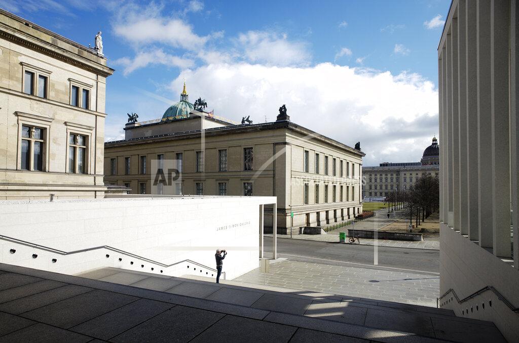 Markus Schreiber A man takes a photo at the James-Simon-Galerie the main entrance of the 'Museumsinsel', Museums Island, in Berlin, Germany, Monday, March 15, 2021. Museums throughout Germany closed at the beginning of November as coronavirus cases increased. Under new regulations, some of the collections on Berlin's Museum Island, one of the city's cultural highlights and a UNESCO World Heritage site, are now allowed to re-open to visitors. (AP Photo/Markus Schreiber)