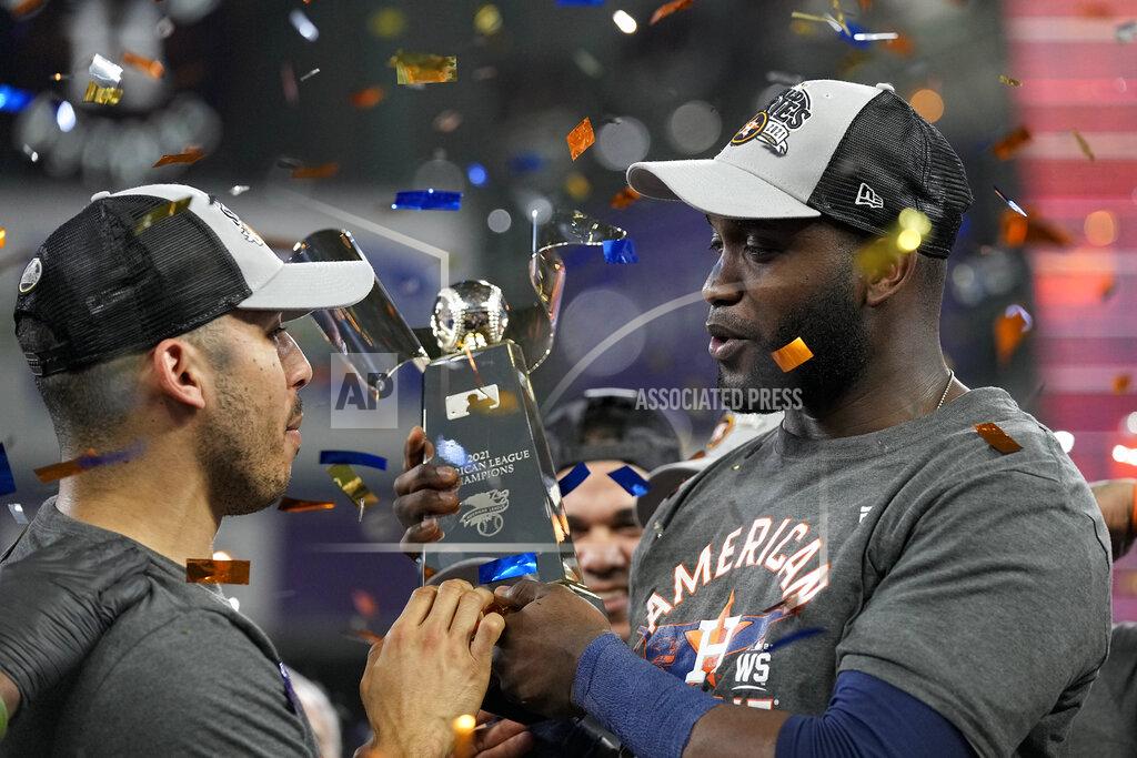 David J. Phillip Houston Astros designated hitter Yordan Alvarez and shortstop Carlos Correa hold the trophy after their win against the Boston Red Sox in Game 6 of baseball's American League Championship Series Friday, Oct. 22, 2021, in Houston. The Astros won 5-0, to win the ALCS series in game six. (AP Photo/David J. Phillip)