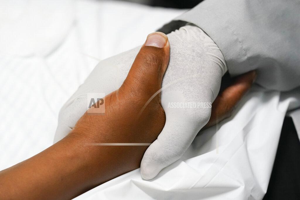 Darron Cummings Larry Brown squeezes the hand of Dr. Jerry Smartt, Monday, Aug. 17, 2020, in Carmel, Ind. There is no end in sight to a rehabilitation that already has lasted months. His hands _ which helped make him Indiana State's eighth all-time receiving leader _ can’t even open a can of soda. (AP Photo/Darron Cummings)