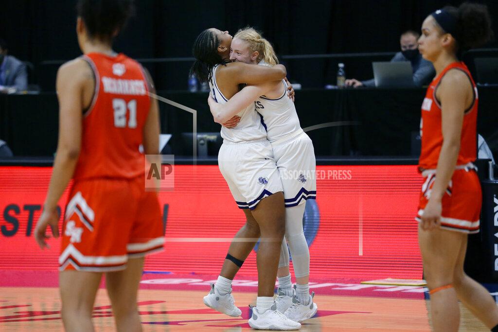 Michael Wyke Stephen F. Austin forward Aiyana Johnson and guard Stephanie Visscher, middle, hug as Sam Houston State forward Madelyn Batista (21) and forward Amber Leggett, right, walk to their bench as the buzzer sounds on SFA's win against Sam Houston State after an NCAA college basketball game for the Southland Conference women's tournament championship Sunday, March 14, 2021, in Katy, Texas. (AP Photo/Michael Wyke)
