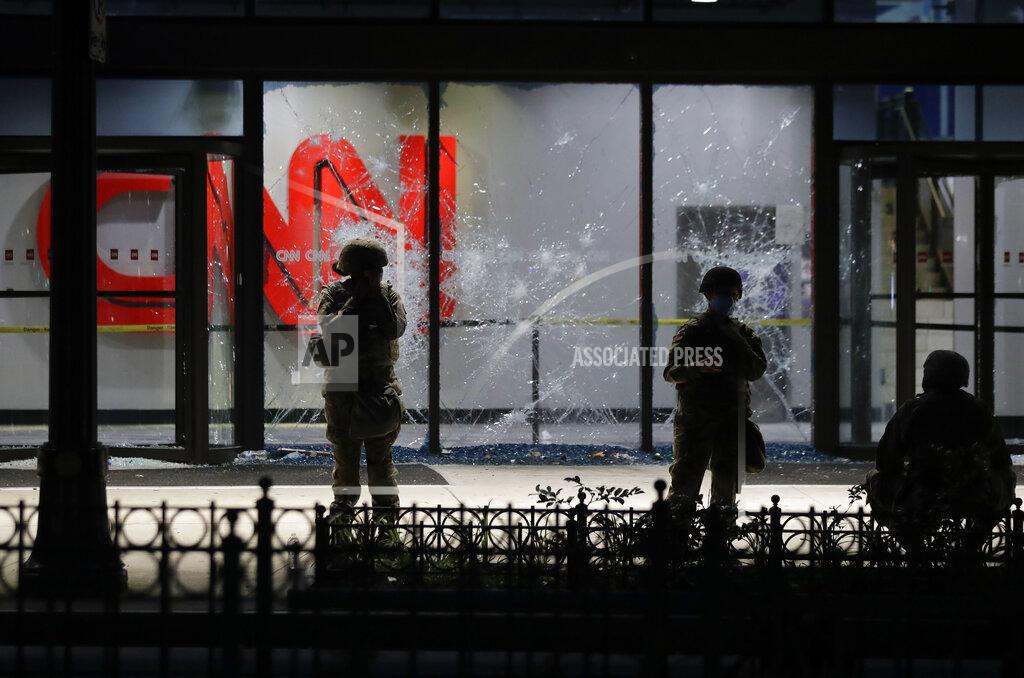 Brynn Anderson Members of the Georgia National Guard stand in front of shattered glass at the CNN Center in the aftermath of a demonstration against police violence on Saturday, May 30, 2020, in Atlanta. (AP Photo/Brynn Anderson)