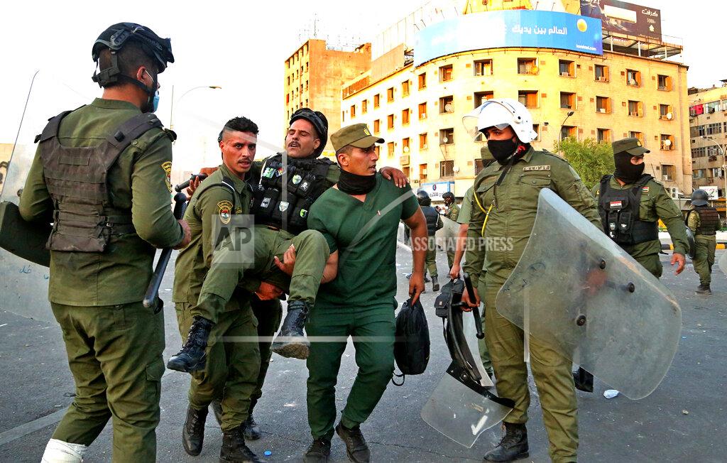 Hadi Mizban A policeman is carried to be treated for his injury during clashes between security forces and anti-government protesters, in Tahrir Square, Baghdad, Iraq, Tuesday, May 25, 2021. Hundreds of Iraqis took to the streets in Baghdad on Tuesday to protest what they say is impunity by those behind a rising number of targeted killings of prominent activists and journalists. (AP Photo/Hadi Mizban)
