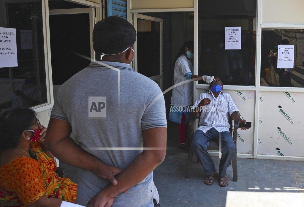 Mahesh Kumar A A health worker takes a nasal swab sample of a man to test for COVID-19 at a hospital in Hyderabad, India, Friday, April 16, 2021. India reported more than 200,000 new coronavirus cases Thursday, skyrocketing past 14 million overall as an intensifying outbreak puts a grim weight on its fragile health care system. (AP Photo/Mahesh Kumar A.)