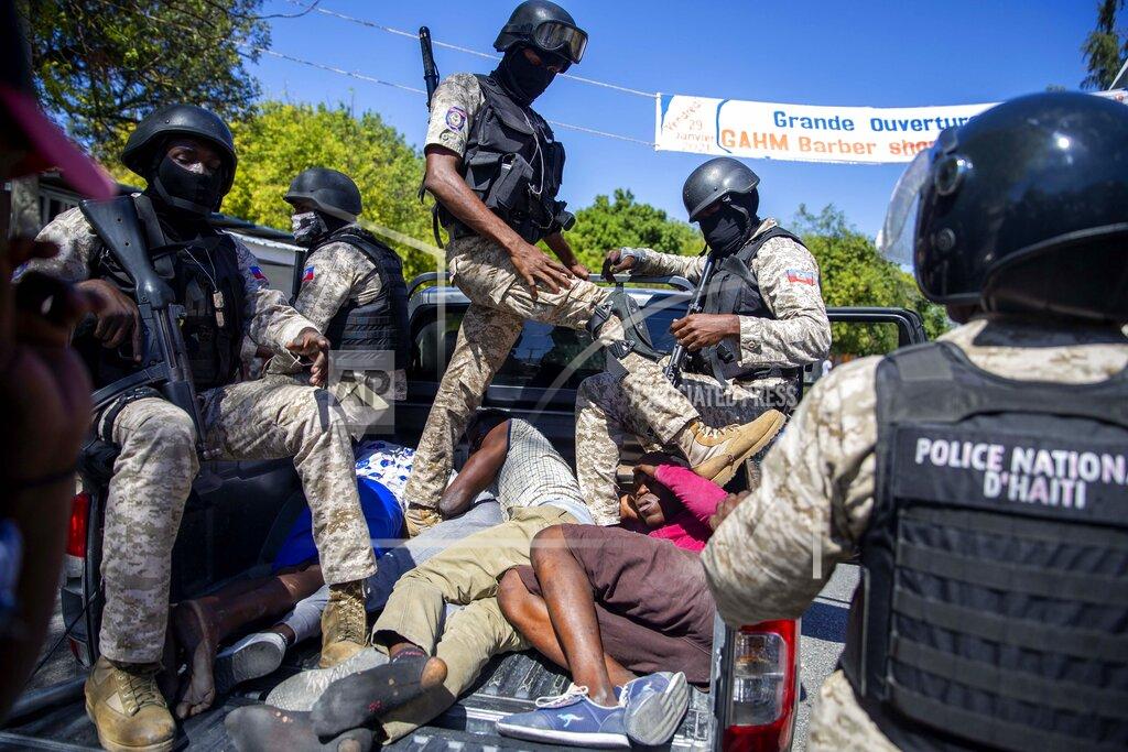 Dieu Nalio Chery Police move detained demonstrators in the bed of a pick-up truck to a police station during a protest to demand the resignation of Haitian President Jovenel Moise in Port-au-Prince, Haiti, Sunday, Feb. 7, 2021. ( AP Photo/Dieu Nalio Chery)