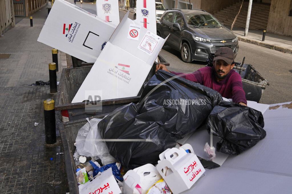 Hassan Ammar A man searches in trash dumpsters for recyclable items to resell next to cardboard voting booths that were used Sunday in the Lebanese parliamentary elections in Beirut, Lebanon, Monday, May 16, 2022. Lebanon's militant Hezbollah group and its allies suffered losses in this weekend's parliamentary elections, with preliminary results Monday showing some of their most vocal opponents picking up more seats and several of their traditional partners routed out of the legislature. (AP Photo/Hassan Ammar)