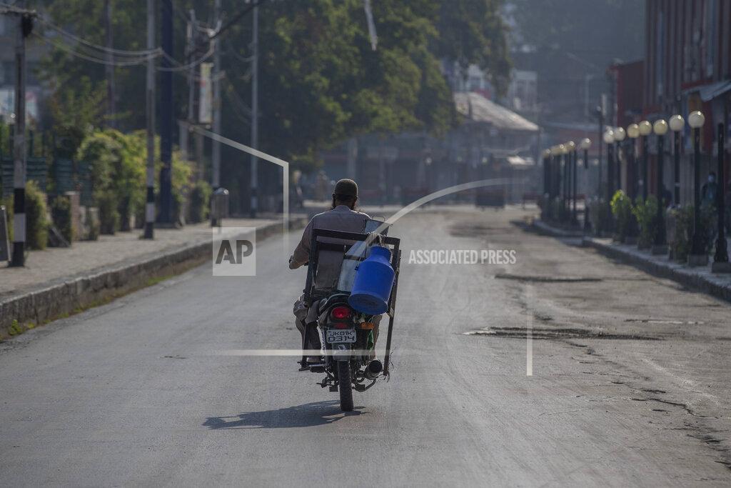 Dar Yasin A Kashmiri milkman drives his motorcycle on a deserted street on the first anniversary of India’s decision to revoke the disputed region’s semi-autonomy, in Srinagar, Indian controlled Kashmir, Wednesday, Aug. 5, 2020. Last year on Aug. 5, India’s Hindu-nationalist-led government of Prime Minister Narendra Modi stripped Jammu-Kashmir of its statehood and divided it into two federally governed territories. Late Tuesday, authorities lifted a curfew in Srinagar but said restrictions on public movement, transport and commercial activities would continue because of the coronavirus pandemic. (AP Photo/ Dar Yasin)
