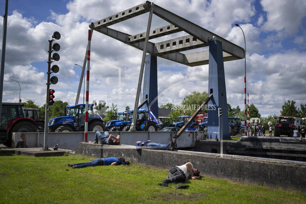 Peter Dejong Protesting farmers block a draw bridge at a lock in the Princess Margriet canal, preventing all ship traffic from passing in Gaarkeuken, northern Netherlands, Monday, July 4, 2022. Dutch farmers angry at government plans to slash emissions also used tractors and trucks Monday to blockade supermarket distribution centers, the latest actions in a summer of discontent in the country's lucrative agricultural sector. (AP Photo/Peter Dejong)