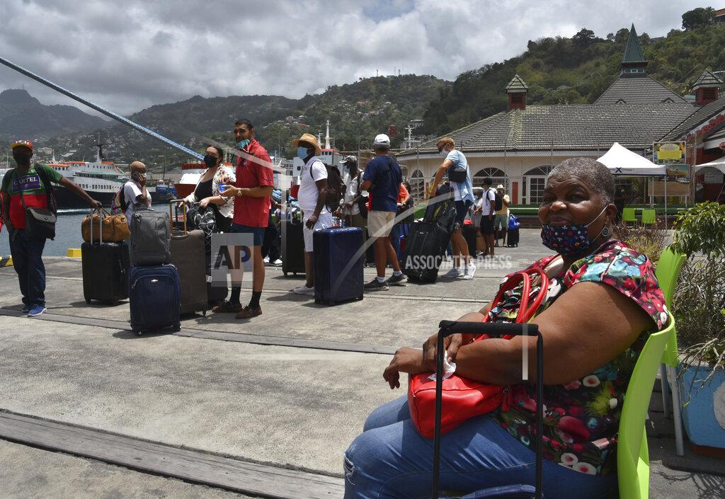 Orvil Samuel British, Canadian and U.S. nationals wait to board the Royal Caribbean cruise ship Reflection to be evacuated free of charge, in Kingstown on the eastern Caribbean island of St. Vincent, Friday, April 16, 2021. La Soufriere volcano has shot out another explosive burst of gas and ash Friday morning as the cruise ship arrived to evacuate some of the foreigners who had been stuck on a St. Vincent island by a week of violent eruptions. (AP Photo/Orvil Samuel)