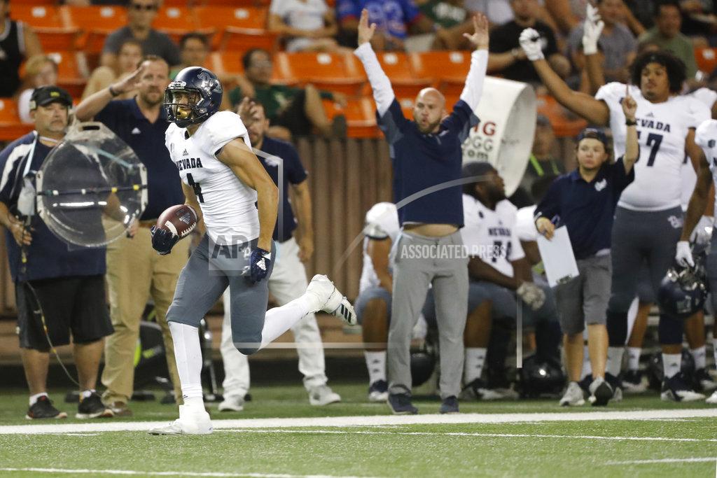 Marco Garcia As the Nevada bench cheers, Nevada wide receiver Elijah Cooks (4) runs the ball in for a third quarter touchdown against Hawaii at an NCAA college football game Saturday, Oct. 20, 2018, in Honolulu. (AP Photo/Marco Garcia)