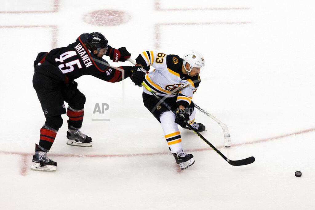Chris Young Boston Bruins' Brad Marchand (63) protects the puck from Carolina Hurricanes' Sami Vatanen (45) during third period NHL Eastern Conference Stanley Cup playoff game in Toronto on Saturday, Aug. 15, 2020. (Chris Young/The Canadian Press via AP)