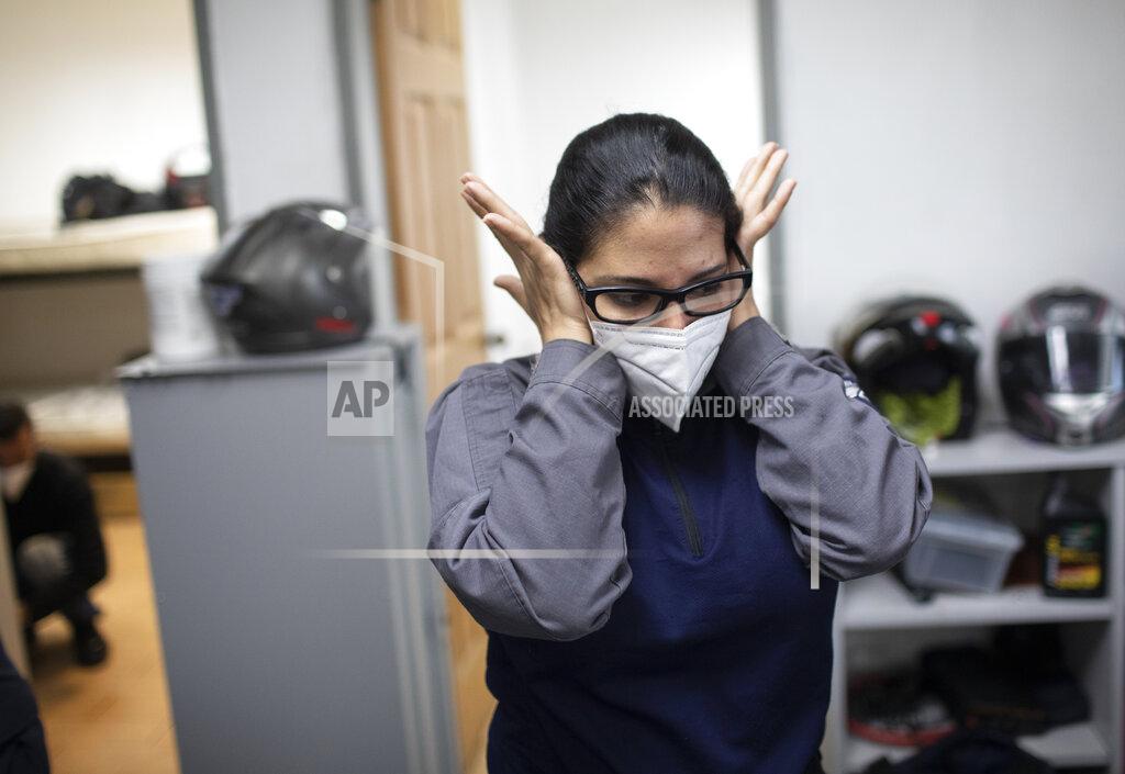 Ariana Cubillos Wearing a mask as a precaution against the new coronavirus, Angels of the Road volunteer paramedic Zully Rodiz rubs her face at the end of her shift at the group's operations base in Caracas, Venezuela, Monday, Feb. 8, 2021. The self-sufficient volunteers seek their own funding and operate entirely independently from the government. (AP Photo/Ariana Cubillos)