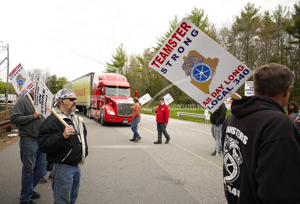 Gregory Rec Randy Willis, left, and other truck drivers with Shaw's supermarkets walk a picket line as a truck, behind, leaves the Shaw's distribution facility, Monday, May 3, 2021, in Wells, Maine. Truck drivers for Shaw's supermarkets represented by the Teamsters went on strike Monday, May 3, stopping shipments to Shaw's and Star Market grocery stores in New England. (Gregory Rec/Portland Press Herald via AP)