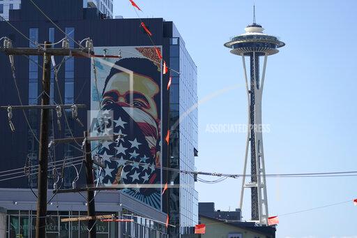 FILE - In this Sept. 2, 2021, file photo, a painting by Shepard Fairey, based on a photo taken by Ted Soqui during a Black Lives Matter protest, is projected onto a building near the Space Needle in Seattle. November's election for Seattle City Attorney pits a Republican versus an extreme liberal candidate who wants to cease most prosecutions of misdemeanor cases, saying the existing system is racist. In many ways the contest has overshadowed the mayoral race as Seattleites will be asked to decide just how far they are willing to go to back social justice policies. (AP Photo/Ted S. Warren, File)