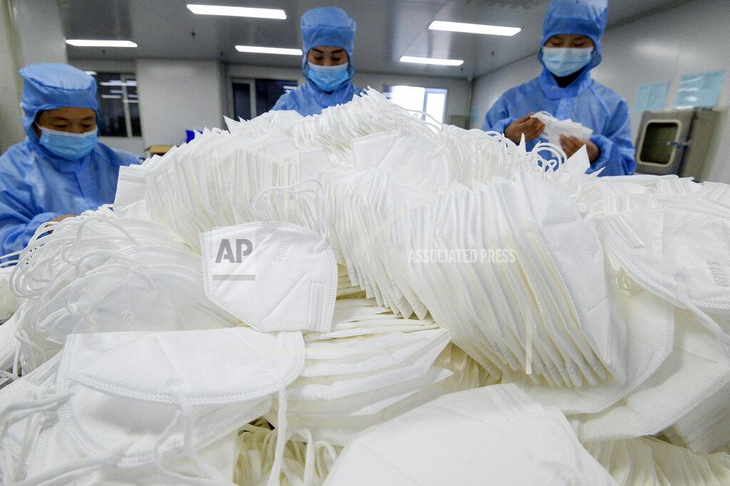 Uncredited Workers wearing face masks to protect themselves from the coronavirus arrange the face masks at a factory in Handan city in north China's Hebei province on Jan. 8, 2021. China's economy grew 2.3% in 2020 as a recovery from the coronavirus pandemic accelerated while the United States, Europe and Japan struggled with disease flare-ups. (Chinatopix via AP)