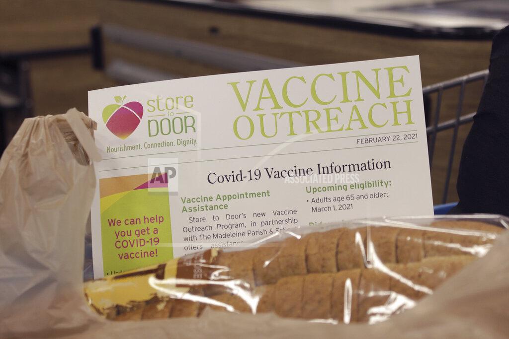 FILE - In this Feb. 25, 2021, file photo a sheet with information about how to get a COVID-19 vaccine sticks out of an order of groceries for delivery to a homebound senior citizen in Portland, Ore., through the nonprofit group Store to Door. Oregon Gov. Kate Brown has announced statewide and county COVID-19 vaccination targets, with the hope of reopening the state's economy. The governor said Tuesday, May 11, most statewide coronavirus related restrictions will be lifted when 70% of Oregon's residents who are 16 years and older receive the first COVID-19 vaccine dose. (AP Photo/Gillian Flaccus, File)