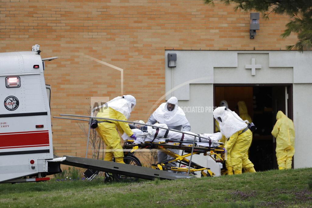 Seth Wenig FILE - In this March 25, 2020, file photo, a resident from St. Joseph's Senior Home is loaded into a bus in Woodbridge, N.J. More than 90 residents of the nursing home in Woodbridge are being transferred to a facility in Whippany, NJ, after 24 tested positive for COVID-19, according to a spokeswoman for CareOne, which operates the Whippany facility. (AP Photo/Seth Wenig, File)