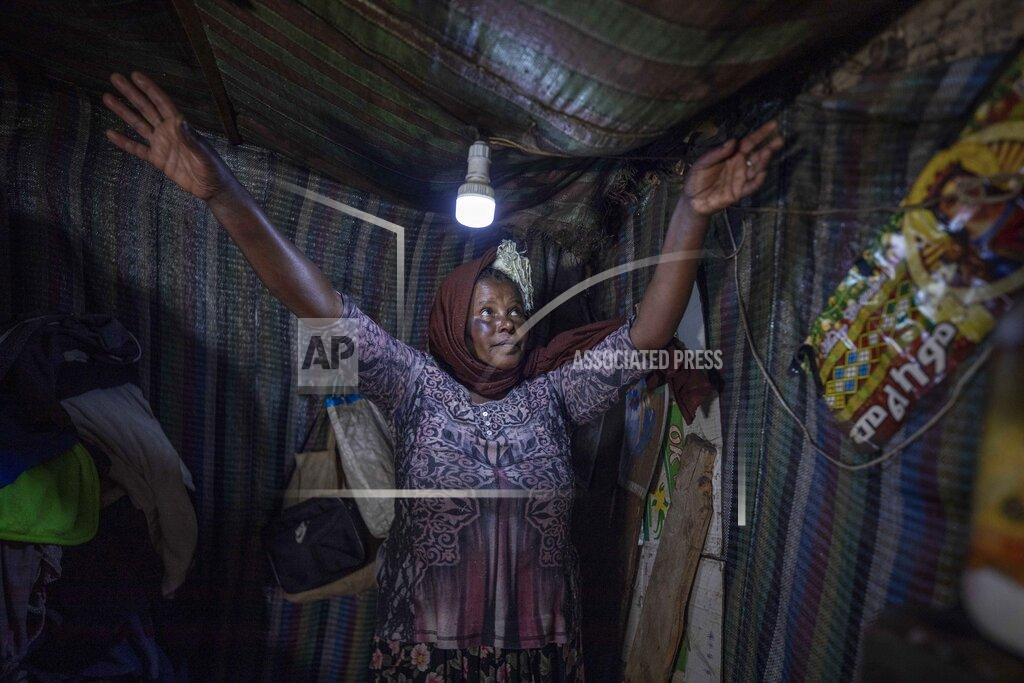 Mother of two Amsale Hailemariam, a domestic worker who lost work because of the coronavirus, stands in her small tent in the capital Addis Ababa, Ethiopia on Friday, June 26, 2020. Decades of progress in one of modern history's greatest achievements, the fight against extreme poverty, are now in danger of slipping away due to the coronavirus and the world could see the first global increase in extreme poverty in 22 years, further sharpening inequality. (AP Photo/Mulugeta Ayene)