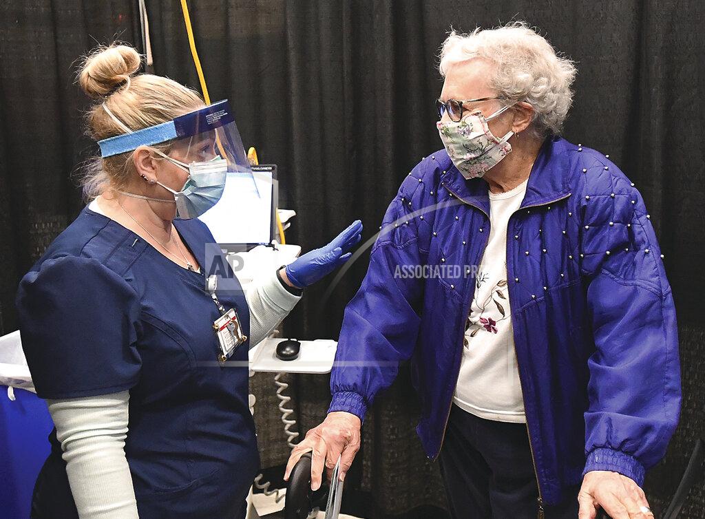 Randy Hoeft Yuma Regional Medical Center registered nurse Candace Manville,left, answers questions for Edith Robbins, 94, after Robbins received a COVID-19 vaccination from Manville during the YRMC vaccination clinic, Thursday, Jan. 28, 2021, inside Yuma Civic Center in Yuma, Ariz. (Randy Hoeft/The Yuma Sun via AP)