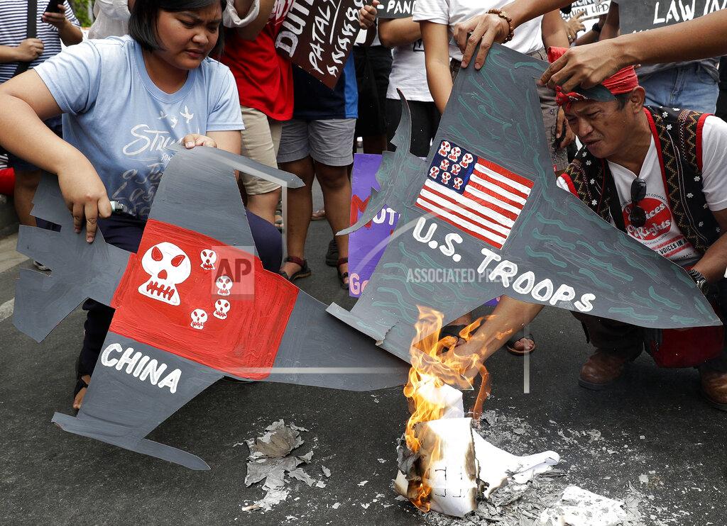 Aaron Favila FILE - In this March 5, 2019, file photo, protesters burn cardboard-cut jet fighters with mock U.S. and China flags as they hold a protest in front of the U.S. embassy in Manila, Philippines. As Americans celebrate or fume over the new president-elect, many in Asia are waking up to the reality of a Joe Biden administration with decidedly mixed feelings. Relief and hopes of economic and environmental revival jostle with needling anxiety and fears of inattention. Some countries in Southeast Asia have shifted focus toward China because of heavy investment and a focus on economic recovery, and “it will take time for the U.S. to rebuild trust,” said Bridget Welsh, honorary research associate at the University of Nottingham in Malaysia. (AP Photo/Aaron Favila, File)