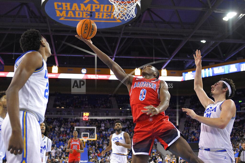 Mark J. Terrill Arizona guard Bennedict Mathurin, center, shoots as UCLA guard Peyton Watson, left, and guard Jaime Jaquez Jr. defend during the second half of an NCAA college basketball game Tuesday, Jan. 25, 2022, in Los Angeles. (AP Photo/Mark J. Terrill)