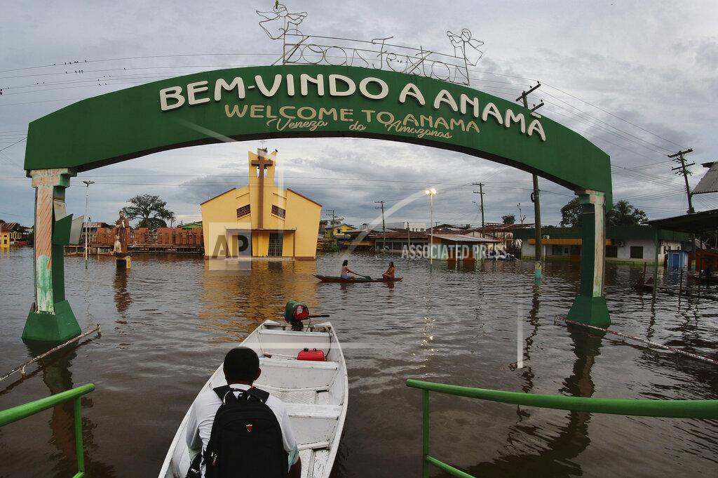 Edmar Barros Residents navigate flooded streets in Anama, Amazonas state, Brazil, Thursday, May 13, 2021. (AP Photo/Edmar Barros)