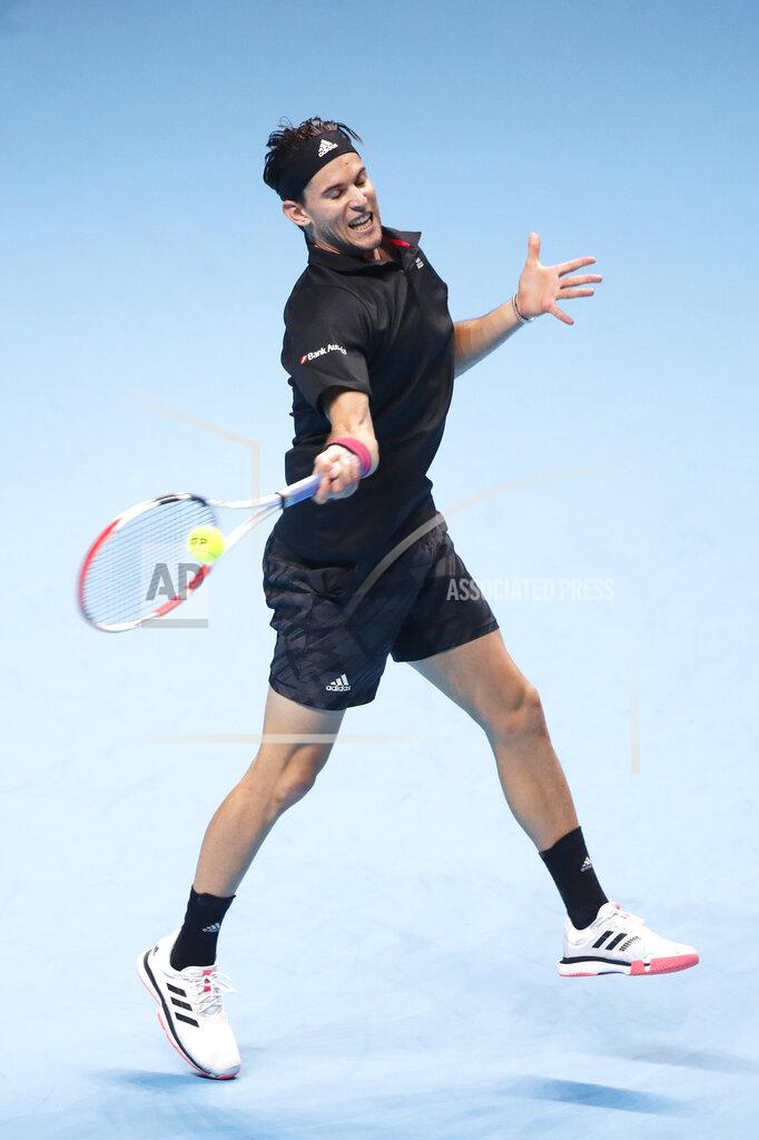 Frank Augstein Dominic Thiem of Austria returns the ball to Novak Djokovic of Serbia during their semifinal match at the ATP World Finals tennis tournament at the O2 arena in London, Saturday, Nov. 21, 2020. (AP Photo/Frank Augstein)