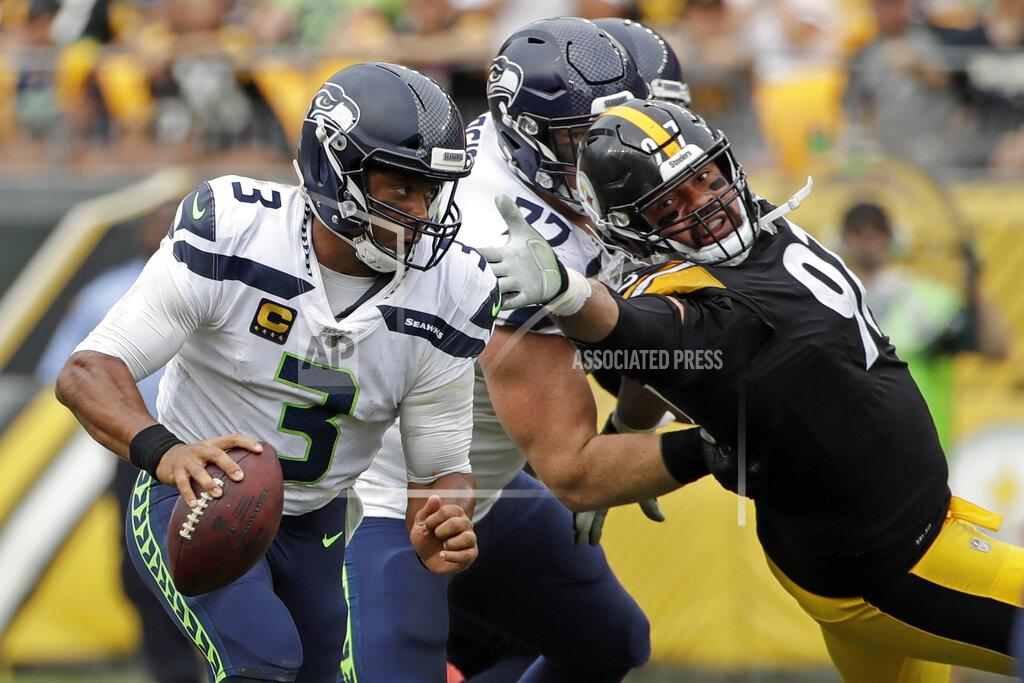 Gene J. Puskar Seattle Seahawks quarterback Russell Wilson (3) scrambles past Pittsburgh Steelers defensive end Cameron Heyward (97), who is blocked by Seahawks offensive guard Ethan Pocic (77) during the second half of an NFL football game in Pittsburgh, Sunday, Sept. 15, 2019. The Seahawks won 28-26. (AP Photo/Gene J. Puskar)