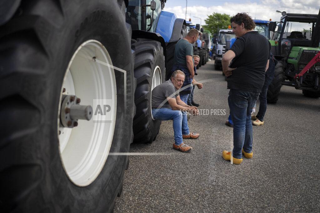 Peter Dejong Protesting farmers talk during a blockade outside a distribution center for supermarket chain Aldi in the town of Drachten, northern Netherlands, Monday, July 4, 2022. Dutch farmers angry at government plans to slash emissions used tractors and trucks Monday to blockade supermarket distribution centers, the latest actions in a summer of discontent in the country's lucrative agricultural sector. (AP Photo/Peter Dejong)
