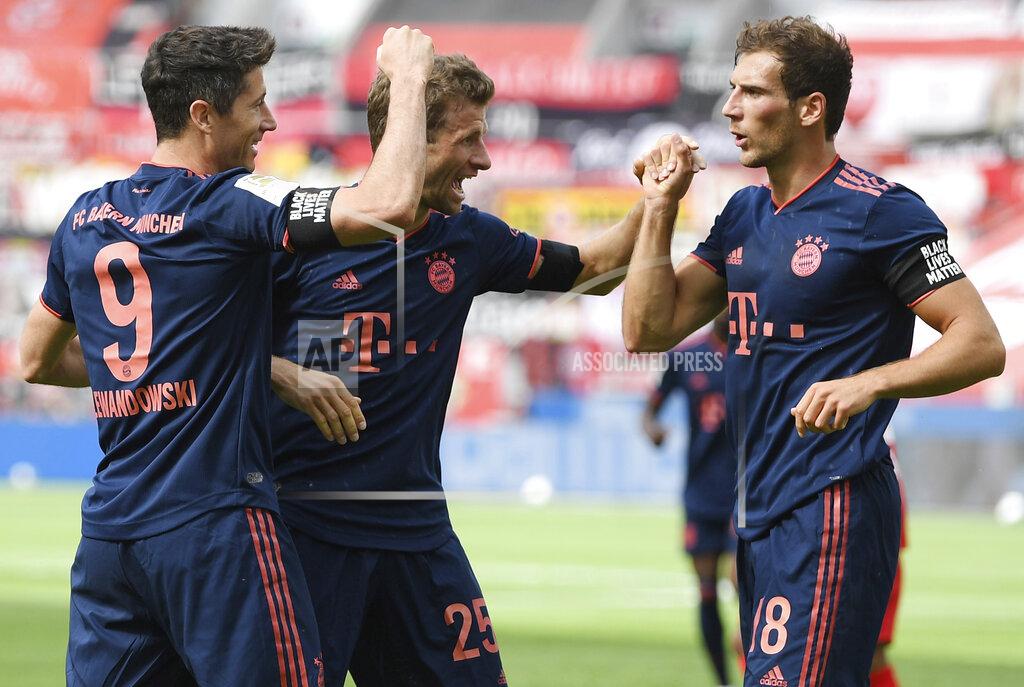 Matthias Hangst Robert Lewandowski, left, of Munich celebrates his team's fourth goal with teammates Thomas Mueller, center, and Leon Goretzka during the German Bundesliga soccer match between Bayer Leverkusen and Bayern Munich in Leverkusen, Germany, Saturday, June 6, 2020. (Matthias Hangst, Pool via AP)