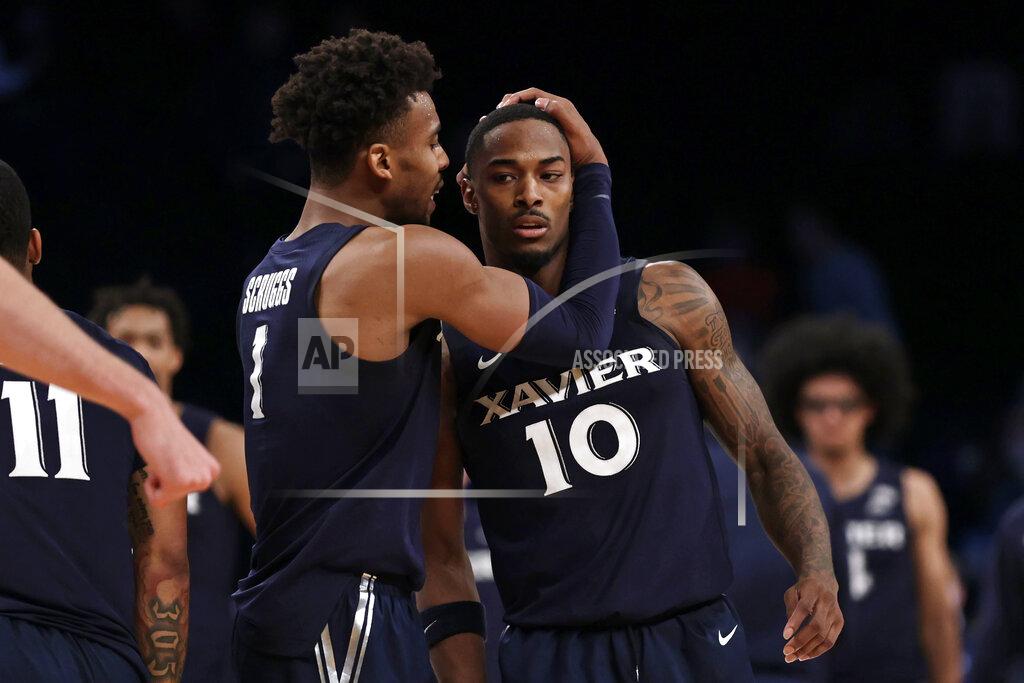 Xavier's Nate Johnson (10) and Paul Scruggs react late in the second half of the team's NCAA college basketball game against Virginia Tech in the NIT Season Tip-Off tournament Friday, Nov. 26, 2021, in New York. Xavier won 59-58. (AP Photo/Adam Hunger)