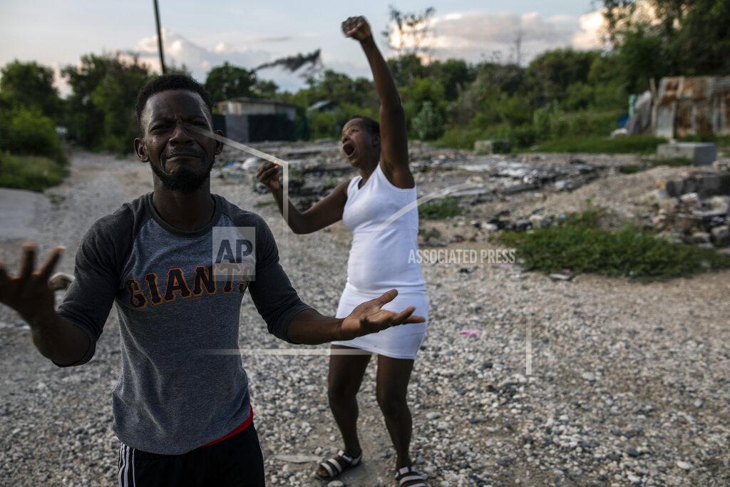 Rodrigo Abd Felix Gelin and Claudine Jean describe in sign language how their community, the La Piste encampment, went up in flames this past summer, in Port-au-Prince, Haiti, Sunday, Sept. 20, 2021. According to residents and a United Nations account, police lead the assault at dusk on the encampment, a shelter for deaf and disabled Haitians relocated there by the International Red Cross after the 2010 earthquake leveled the capital. (AP Photo/Rodrigo Abd)