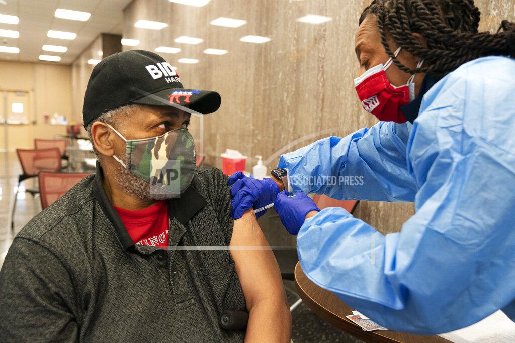 Jacquelyn Martin In this Thursday, Feb. 11, 2021, photo Reginald Henry, 69, of Washington, receives his second dose of the COVID-19 vaccine at a clinic at Howard University, in Washington. "I felt confident about getting the vaccine," says Henry, who lives in a senior building, "because God helps those who help themselves." (AP Photo/Jacquelyn Martin)