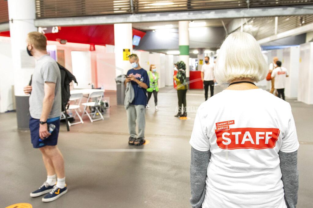 Dominic Lipinski People queue at a mass coronavirus vaccination centre held in Arsenal's Emirates Stadium, in north London, Friday June 25, 2021. (Dominic Lipinski/PA via AP)
