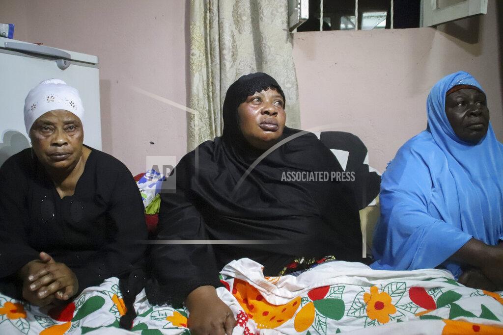 Justin Kabumba Asina Selemani, center, the widow of World Food Programme (WFP) driver Moustapha Milambo, who was killed in the attack on a U.N. convoy that also killed the Italian ambassador to Congo and an Italian Carabinieri police officer, sits at her home in Goma, North Kivu province, Congo, Tuesday, Feb. 23, 2021. An Italian Carabinieri unit is expected in Congo Tuesday to investigate the killings of the Italian ambassador to Congo, an Italian Carabinieri police officer and their driver in the country's east. (AP Photo/Justin Kabumba)