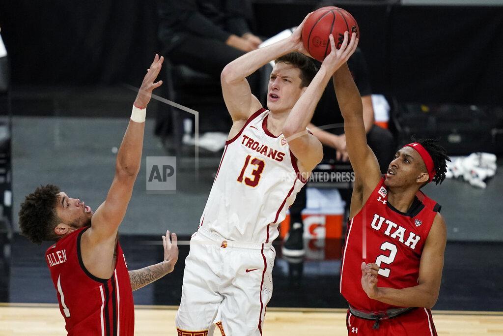 John Locher Southern California's Drew Peterson (13) shoots over Utah's Timmy Allen, left, and Ian Martinez (2) during the second half of an NCAA college basketball game in the quarterfinal round of the Pac-12 men's tournament Thursday, March 11, 2021, in Las Vegas. (AP Photo/John Locher)