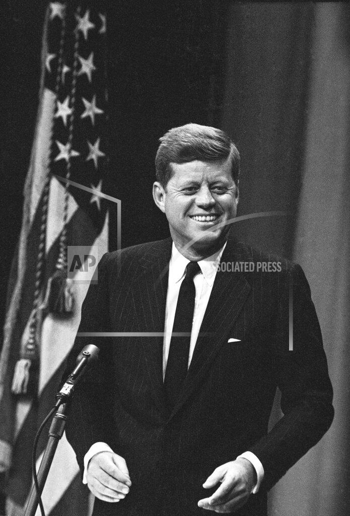 Anonymous FILE - In this Jan. 25, 1961, file photo President John Kennedy smiles during his first live televised news conference as the new chief executive. The conference, held in the auditorium of the State Department building, drew more than 400 reporters. (AP Photo)