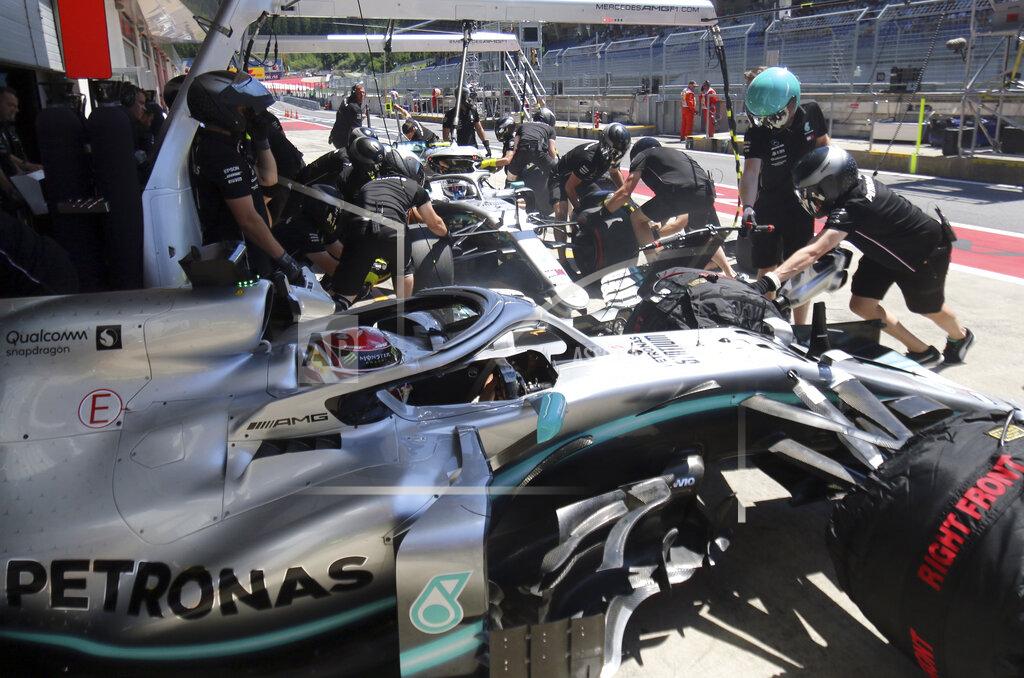 Ronald Zak Mercedes driver Lewis Hamilton of Britain, in the foreground, sits in his car as mechanics work on the car of teammate Valtteri Bottas of Finland, in the background, during the first free practice session for the Austrian Formula One Grand Prix at the Red Bull Ring racetrack in Spielberg, southern Austria, Friday, June 28, 2019. The race will be held on Sunday. (AP Photo/Ronald Zak)
