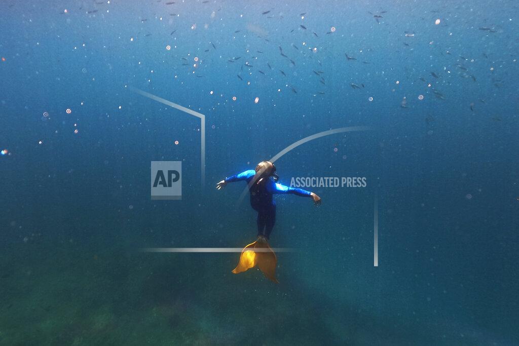 Aaron Favila Queen Pangke Tabora swims in her monofin as she demonstrates techniques to her mermaiding class in Mabini, Batangas province, Philippines on Saturday, May 21, 2022. The former insurance company worker described the experience of gliding under water, half-human and half-fish, as “meditation in motion.” (AP Photo/Aaron Favila)