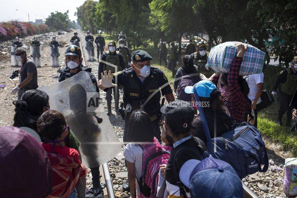 Rodrigo Abd A policeman talks to day laborers and informal workers at a police blockade on the outskirts of Lima, Peru, Saturday, April 18, 2020. Because the strict quarantine rules amid the new coronavirus pandemic do not allow for inter-province travel, the workers have been living on the side of the road for days blocked by police from returning to their homes which are located outside the capital. (AP Photo/Rodrigo Abd)